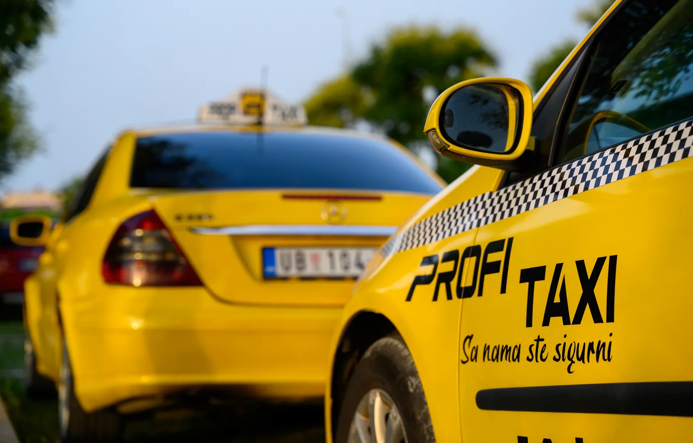 Detalj žutog vozila sa oznakom Profi Taxi i natpisom Sa nama ste sigurni