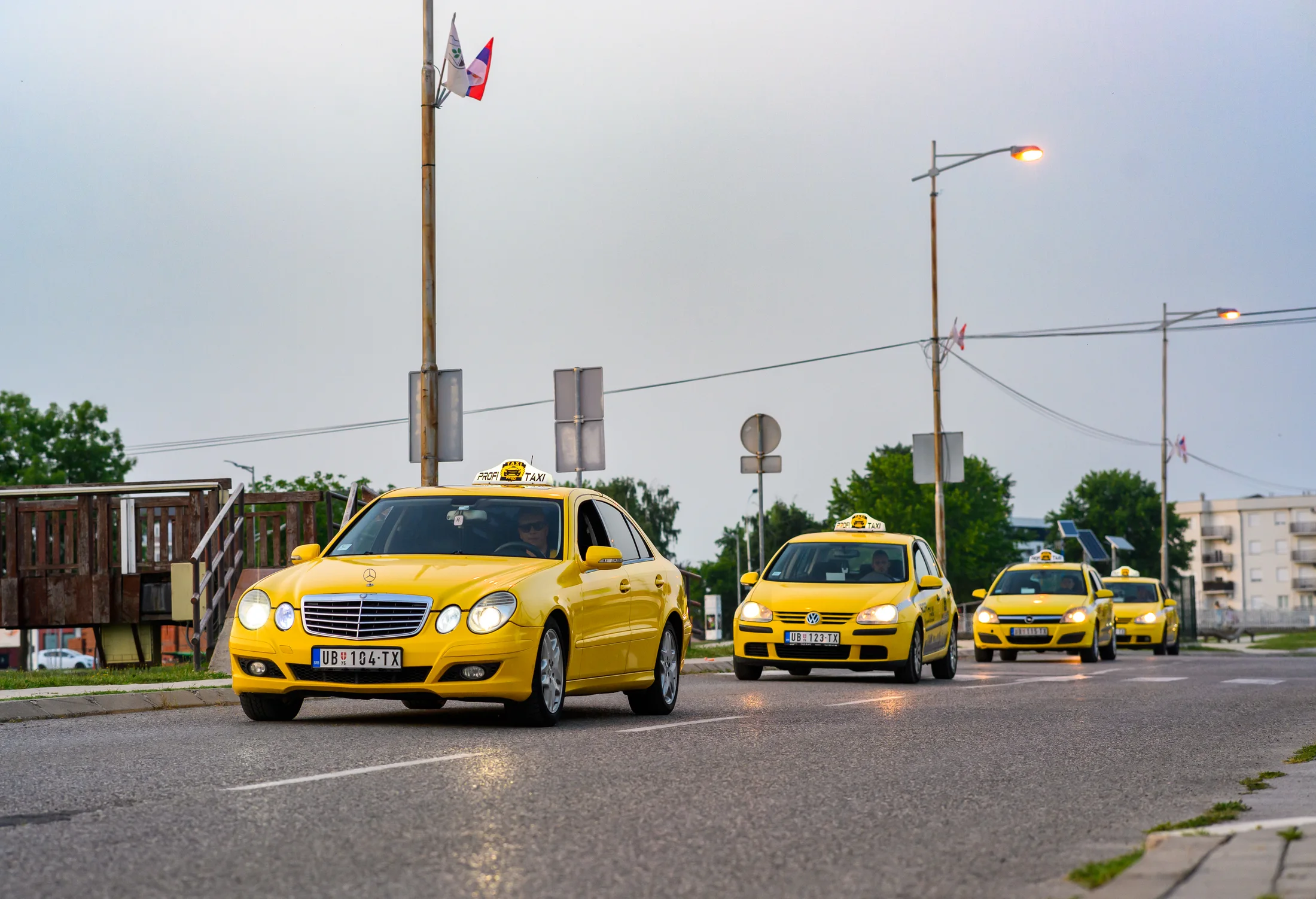 Žuta vozila Profi Taxi u vožnji kroz Ub